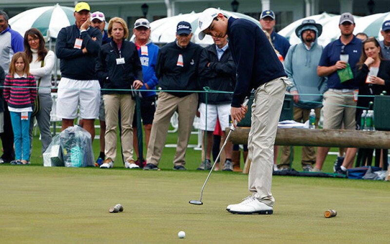 Patrick Welch in the Boys 14-15 division putts